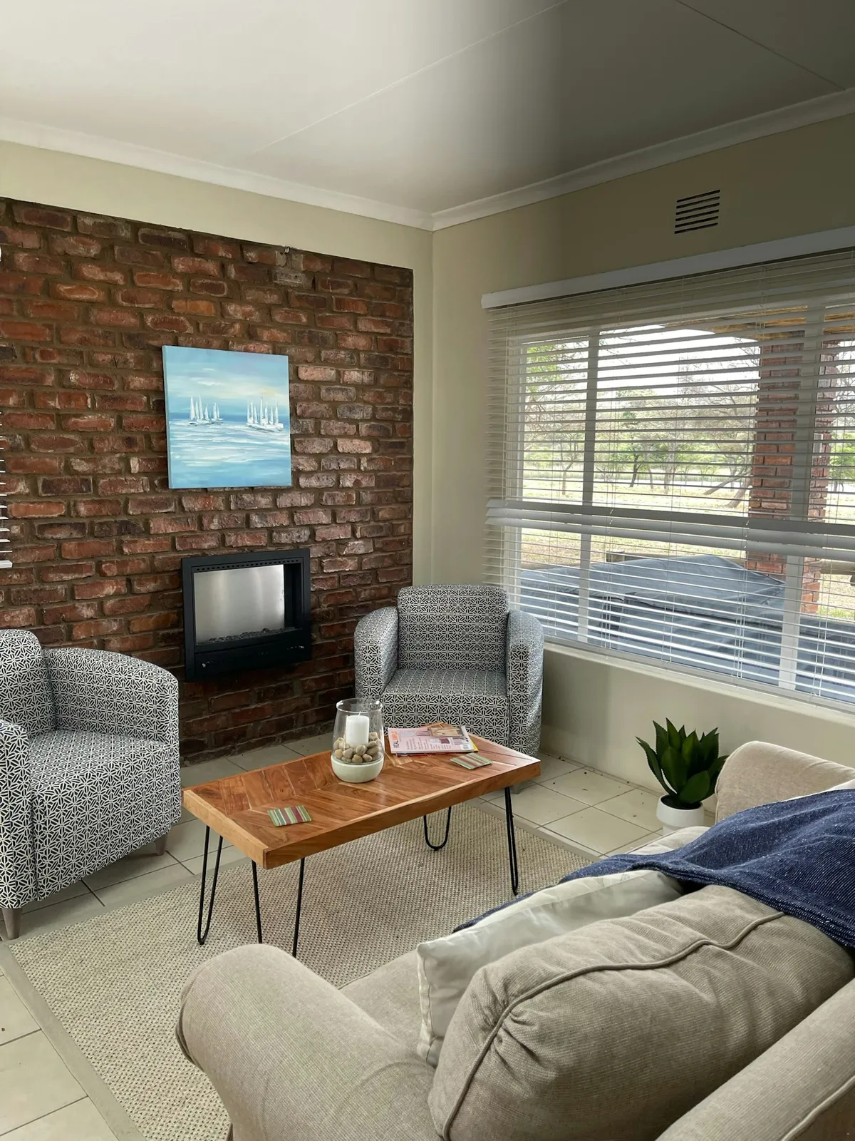 Lounge with fireplace and armchairs at Sunfish, Groendraai River Cottages | Groendraai River Cottages - Sunfish - Limpopo - Vaalwater