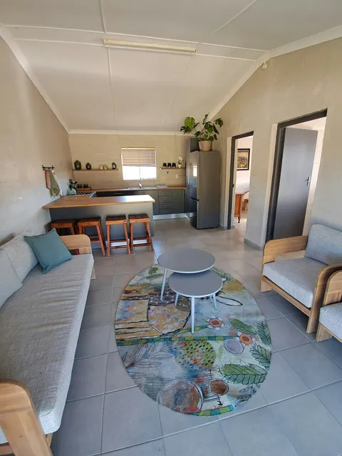 Lounge and kitchen with sofas at Chalet 1, FleckVieh | Fleckvieh Guest Farm - Chalet 1 - Western Cape - Swellendam