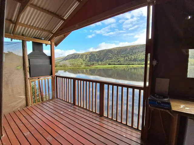 Deck overlooking a dam with a braai at Steenbokkie Tent, FleckVieh | Fleckvieh Guest Farm - Steenbokkie Tent - Western Cape - Swellendam