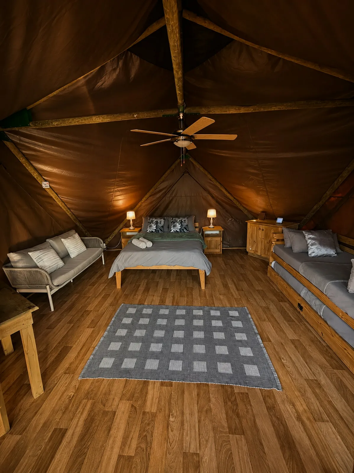 Tent interior with beds and a sofa at Grysbokkie Tent, FleckVieh | Fleckvieh Guest Farm - Grysbokkie Tent - Western Cape - Swellendam