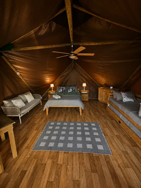 Tent interior with beds and a sofa at Grysbokkie Tent, FleckVieh | Fleckvieh Guest Farm - Grysbokkie Tent - Western Cape - Swellendam