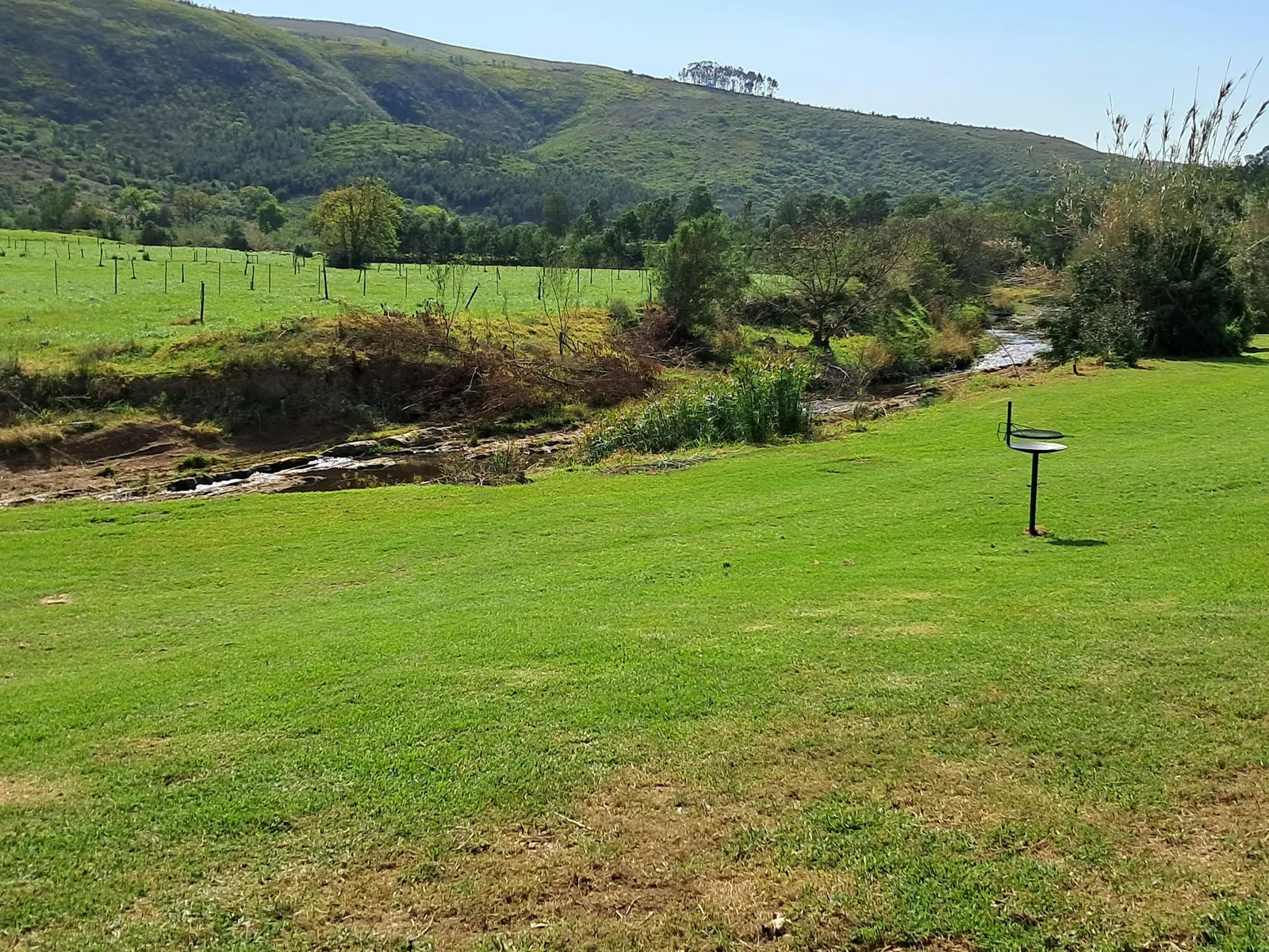 Stream through grass below hills at Camp Site Stream, FleckVieh | Fleckvieh Guest Farm - Camp Site Stream - Western Cape - Swellendam