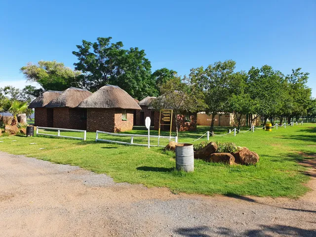 Brick rondavels under trees | Klerksdorp Dam Holiday Resort - North West - Klerksdorp - Klerksdorp Dam