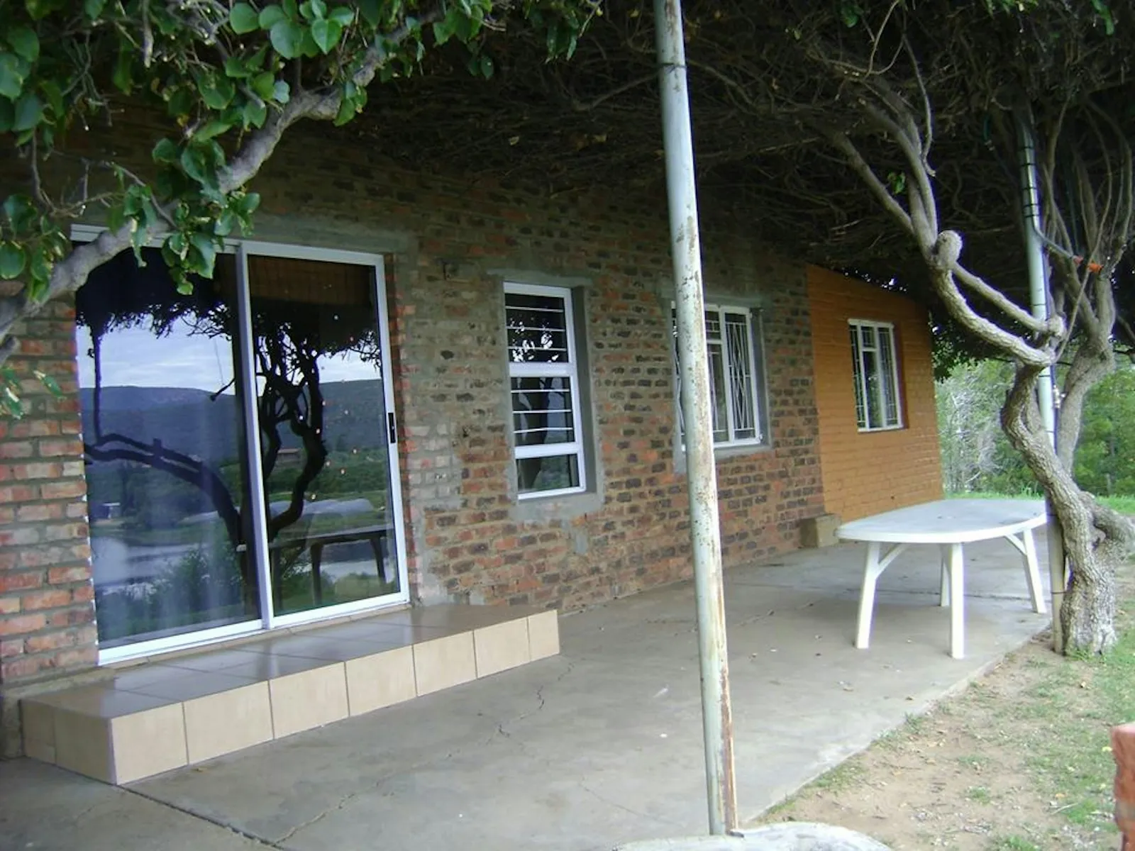 Brick cottage patio under a vine canopy at 7-Sleeper 3-bedroom Cottage 2, Rondegat Guest Farm | Rondegat Guest Farm - 7-Sleeper 3-bedroom Cottage 2 - Western Cape - Clanwilliam - Clanwilliam Dam