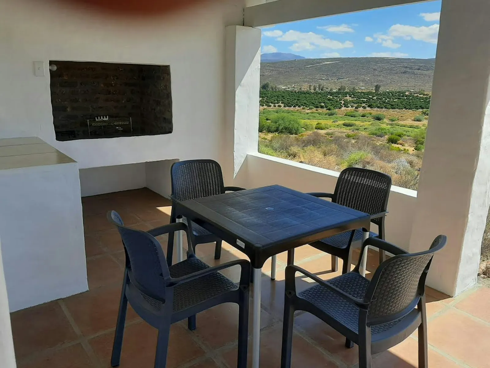 Covered patio table beside a built-in braai at Hilltop Cottages 1 and Hilltop Cottages 2, Rondegat Guest Farm | Rondegat Guest Farm - Hilltop Cottages 1 - Western Cape - Clanwilliam - Clanwilliam Dam