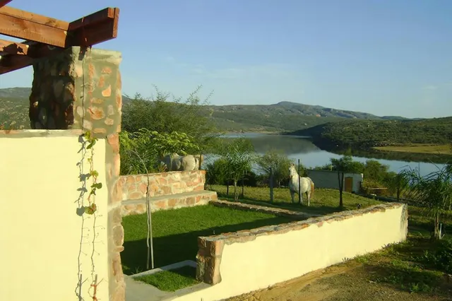 Walled lawn with a white horse above the water at 5-Sleeper 2-bedroom Cottage 1, Rondegat Guest Farm | Rondegat Guest Farm - 5-Sleeper 2-bedroom Cottage 1 - Western Cape - Clanwilliam - Clanwilliam Dam