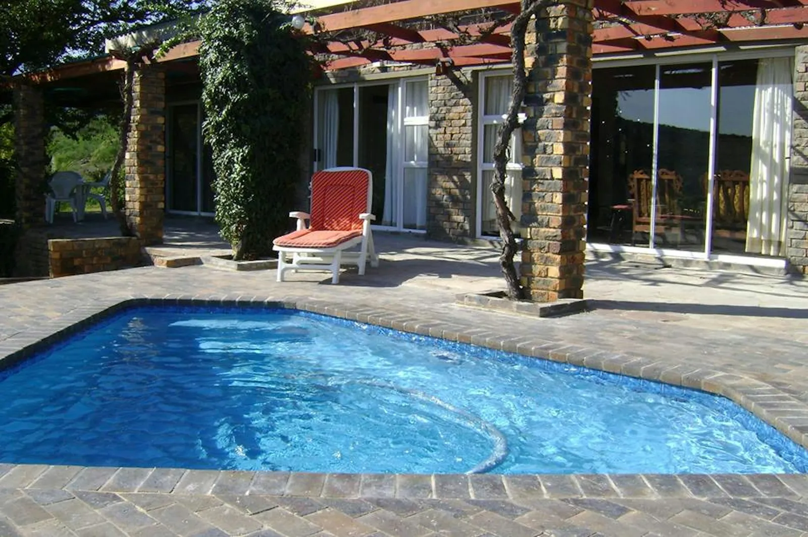 Pool and red lounger on a paved patio at Lakeview House, Rondegat Guest Farm | Rondegat Guest Farm - Lakeview House - Western Cape - Clanwilliam - Clanwilliam Dam